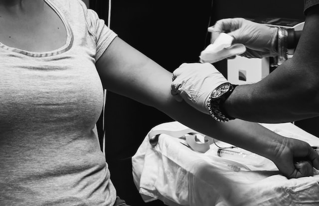 A woman undergoes a blood draw procedure at a clinic. Photo by Obi - @pixel7propix  on Unsplash